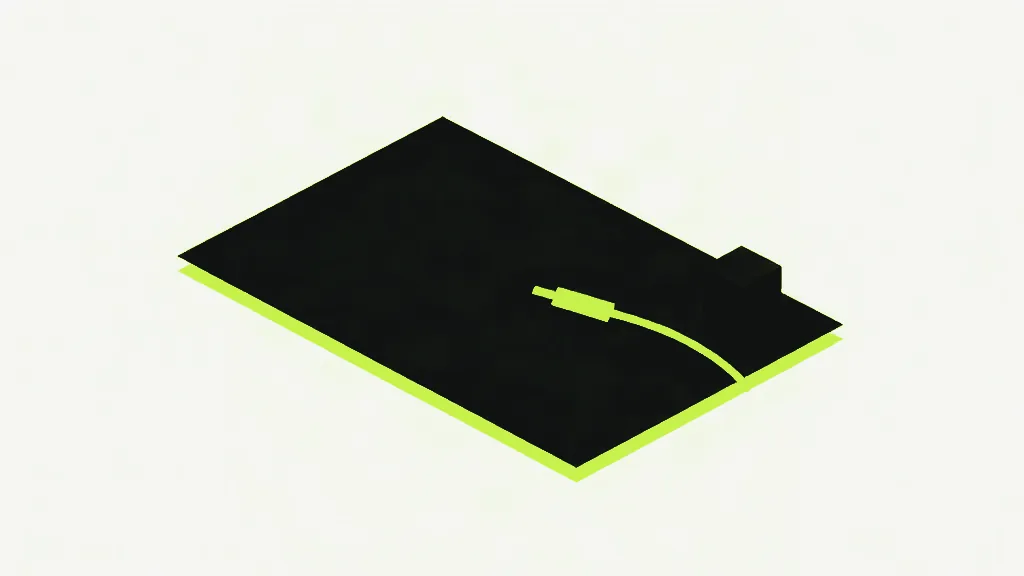 A dark flat slab with a bright edge, an unplugged bright cable lying loose across it and a small dark cube still sitting at its far corner