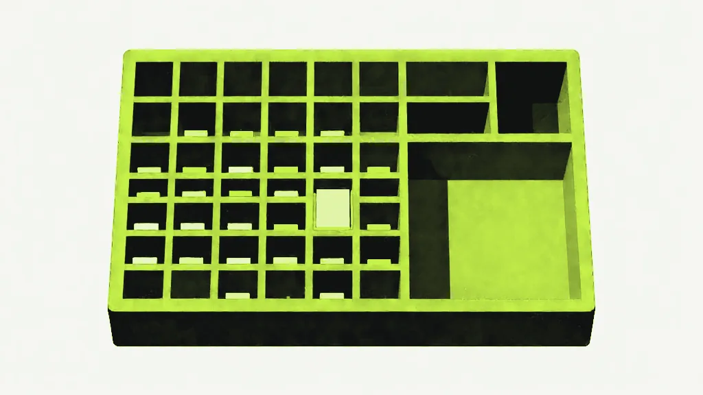 A bright compartment tray, most of its cells holding small dark blocks, with one corner group of cells standing empty